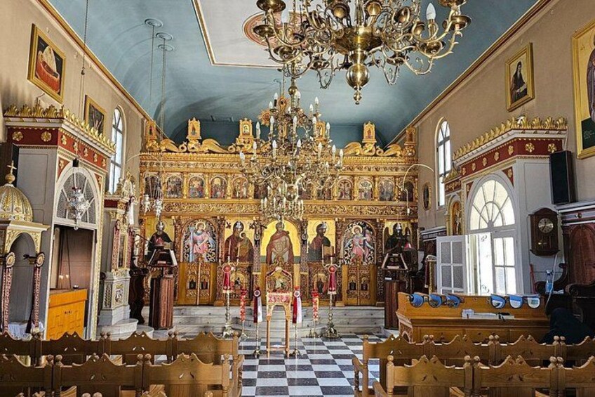 L’intérieur d’une église richement décorée, avec un grand lustre, un autel doré et un sol à carreaux. 2