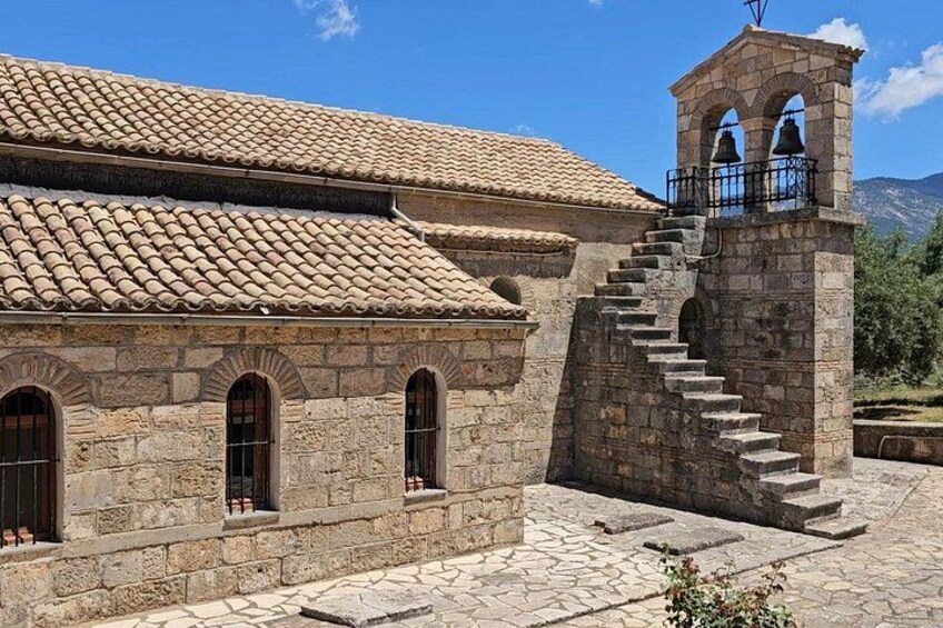 Un bâtiment en pierre avec un toit en tuiles, un clocher et un escalier menant au sommet du clocher. 5