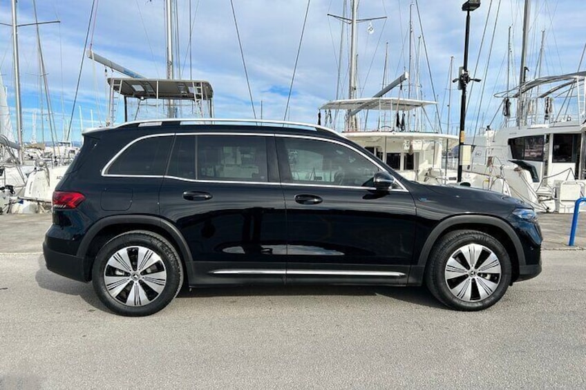 En sort SUV parkeret i en lysthavn med både i baggrunden. 4