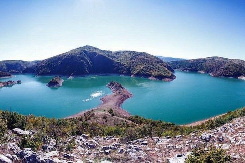 A mountainous landscape with a large body of water surrounded by hills. 3