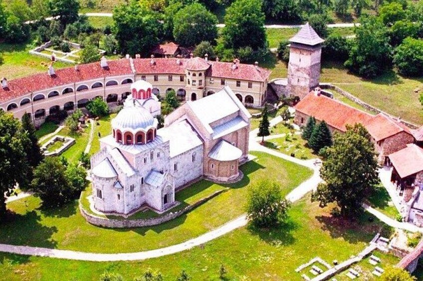 A historic monastery complex with a central church, a bell tower, and surrounding cloisters. 5