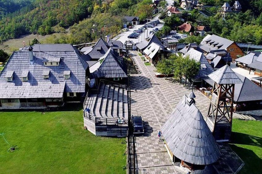 Ein Dorf mit traditionellen Häusern unter Reetdächern und einem zentralen Platz. 5