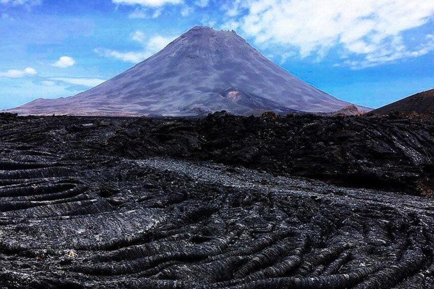 A volcanic landscape with a prominent mountain and patterned ground. 4