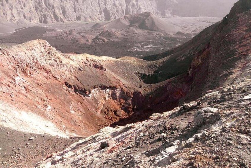 A rugged mountainous landscape with a deep valley and a small body of water. 2