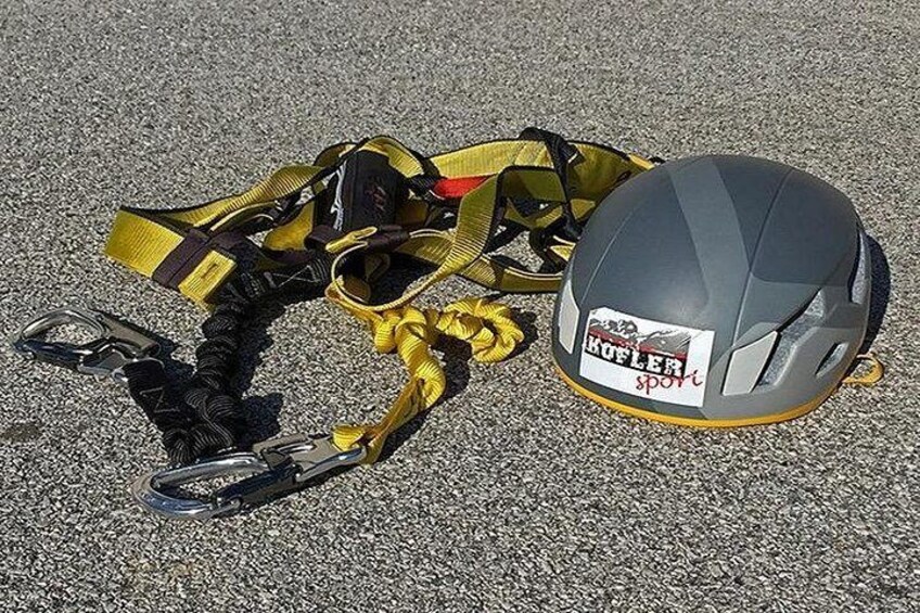 A helmet and harness on a textured surface. 1