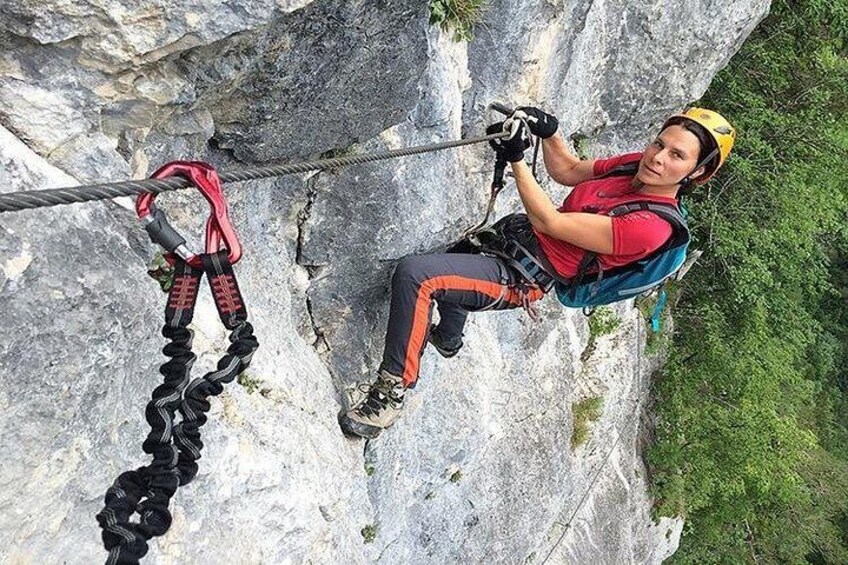 A person rock climbing on a cliff with safety gear and a harness. 2
