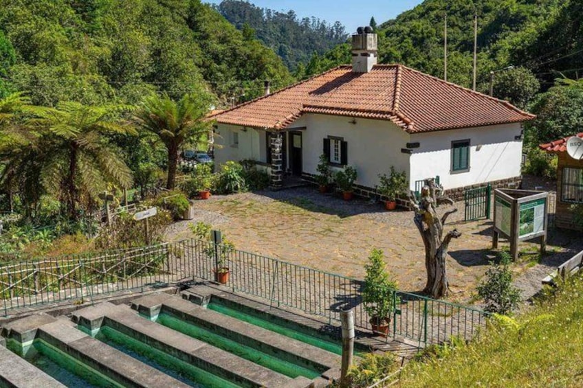 A house with a red-tiled roof, surrounded by greenery and a stone staircase leading to a green area. 3