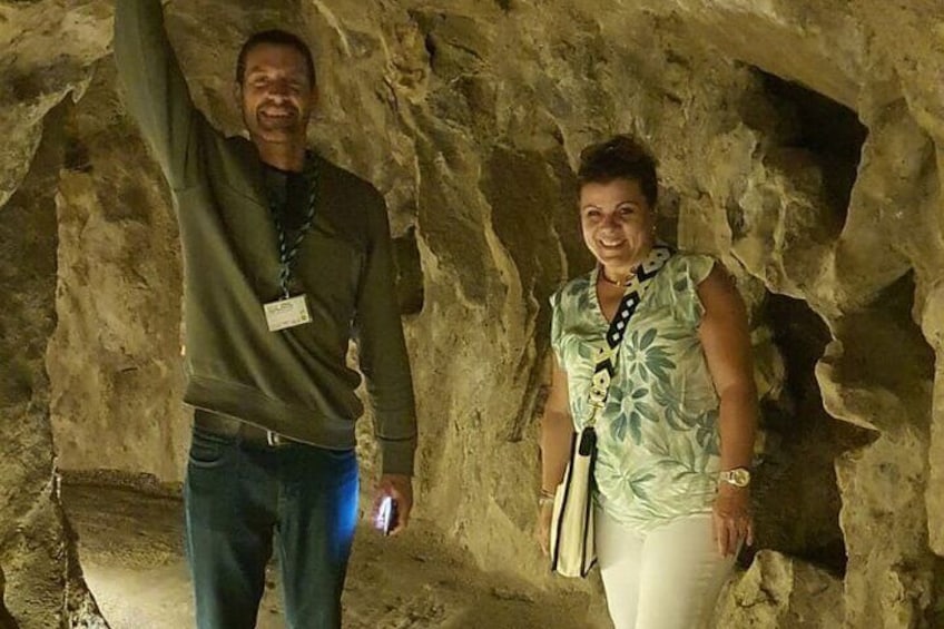Twee personen staan in een grot met rotswanden. 2