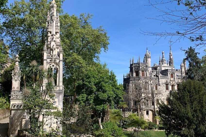 Een historisch kasteel met gedetailleerde architectuur, omringd door weelderige begroeiing. 3