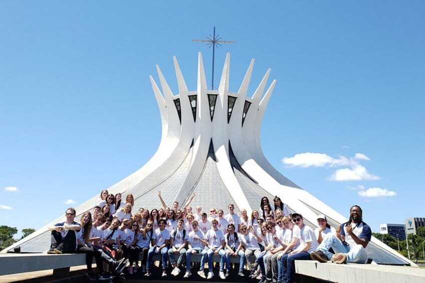 A group of people posing in front of a modern architectural structure with a unique design. 2