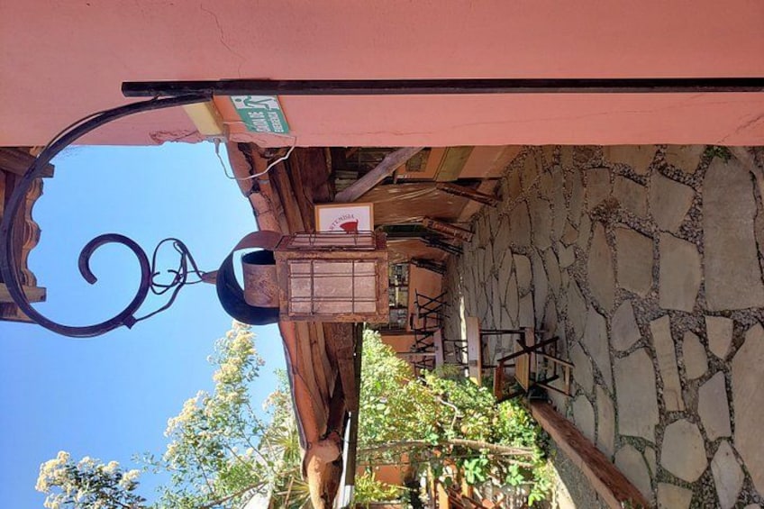 A stone wall, a hanging light fixture, and a wooden structure. 1