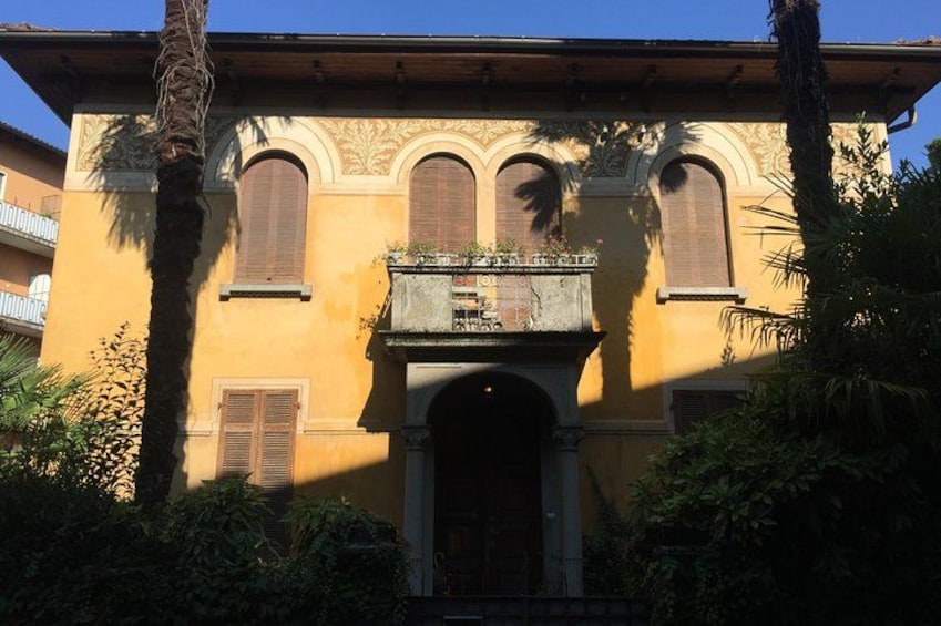 A yellow building with arched windows and a balcony. 4
