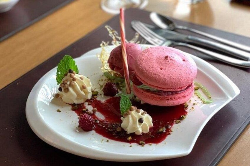 En desserttallerken med macarons, flødeskum og bær. 3