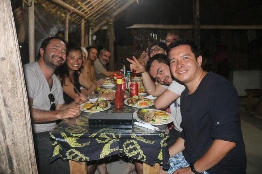 A group of people dining at an outdoor table with a wooden structure in the background. 5