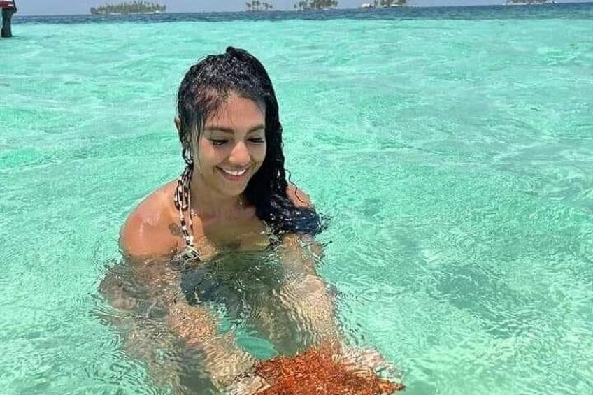 A person in clear turquoise water, possibly snorkeling or swimming. 2