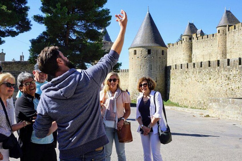 A group of people near a historic castle with a tall tower. 1