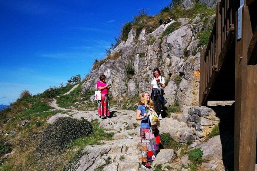Un groupe de personnes se trouve sur un sentier de randonnée rocheux, avec une structure en bois sur la droite. 1