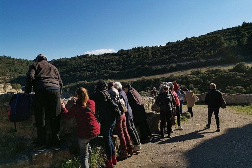 Un groupe de personnes marchant sur un sentier de terre, avec un paysage vallonné en arrière-plan. 5