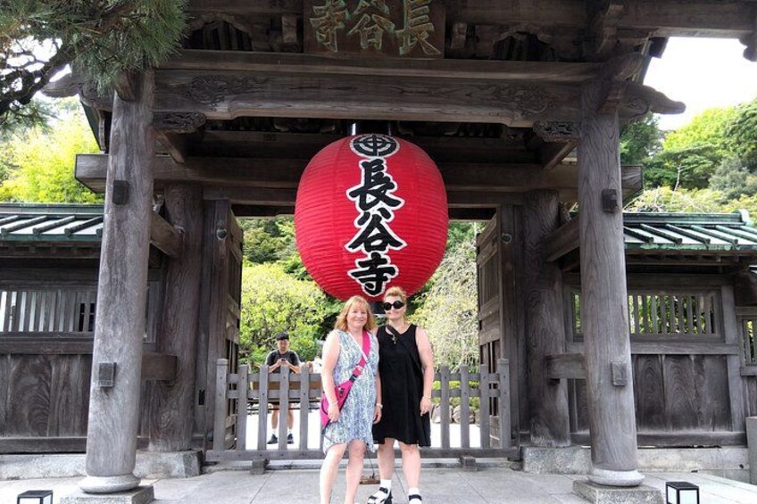 Een traditionele Japanse poort met een rode lantaarn en houten pilaren. 3