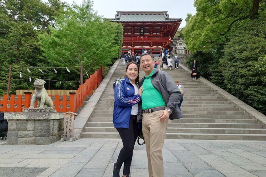 A traditional Japanese temple with a red gate, stone steps, and a stone lion statue. 4