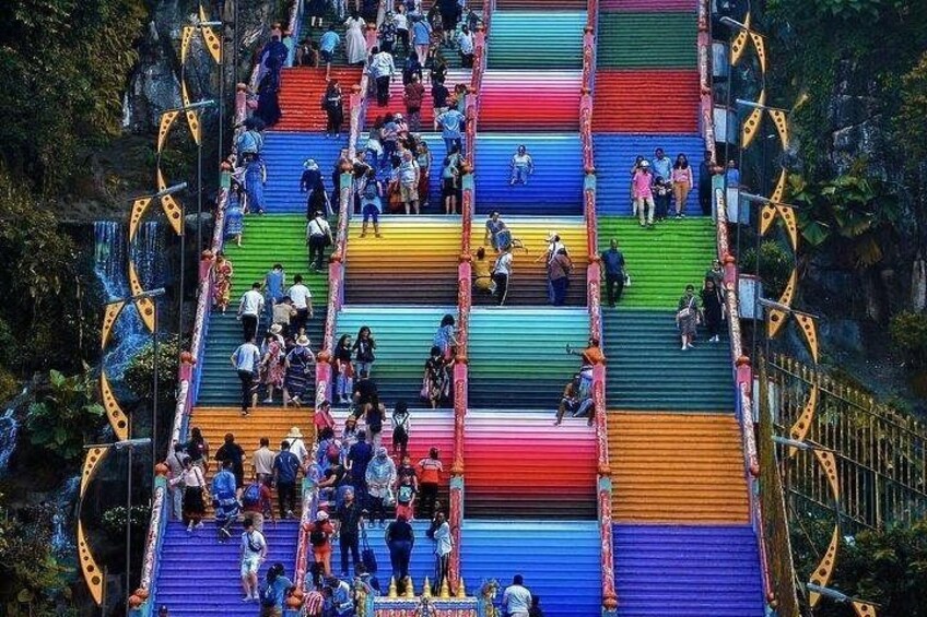 A multi-colored staircase with people ascending and descending. 1