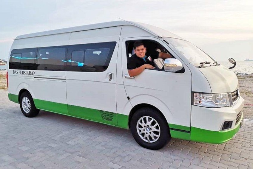 A white van with green accents parked on a paved surface near a body of water. 4