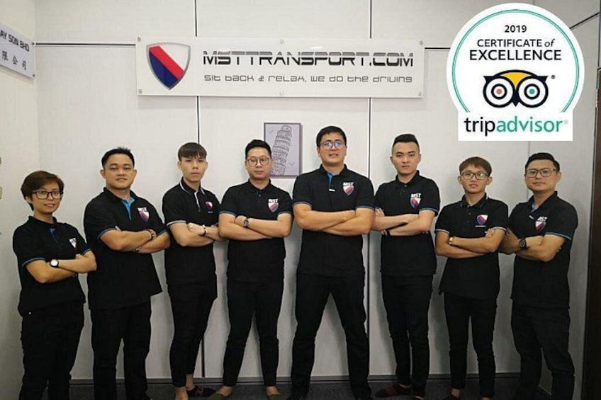 A group of people in black uniforms standing in front of a wall with a sign and a certificate. 3