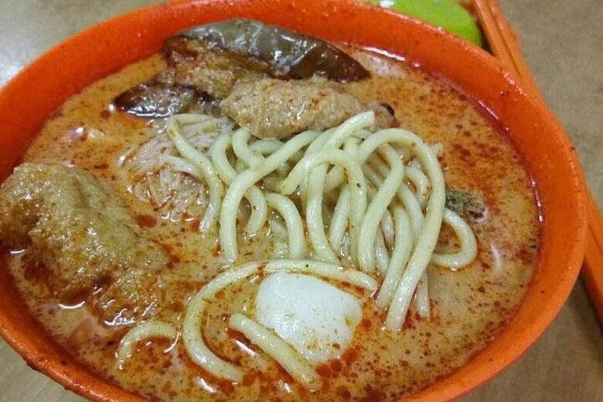 A bowl of noodle soup with meat and vegetables. 2