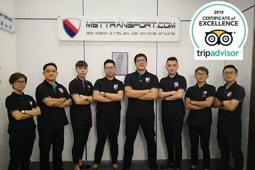 A group of people in black uniforms standing in front of a wall with a sign and a TripAdvisor logo. 2