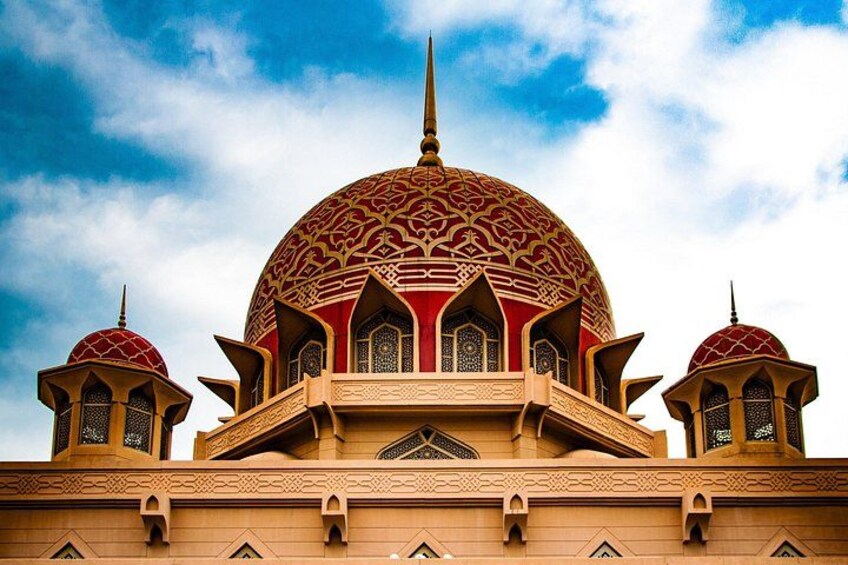 A large mosque with a prominent dome and two smaller domes, intricate geometric patterns, and a tall minaret. 1