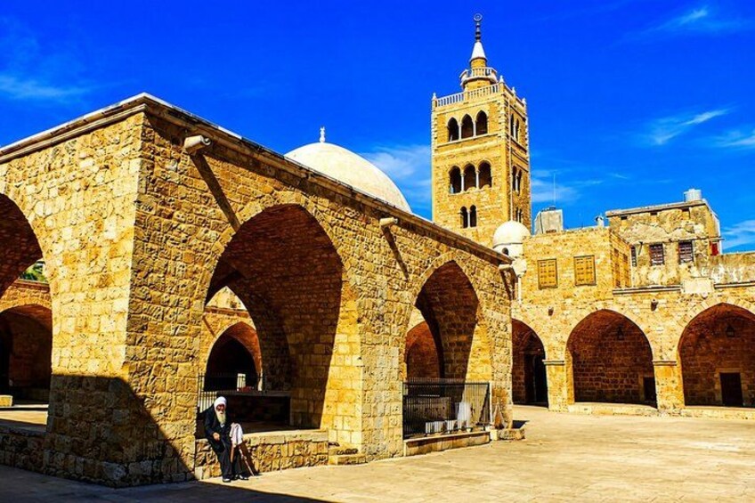 A historic stone building with arches and a tower. 2