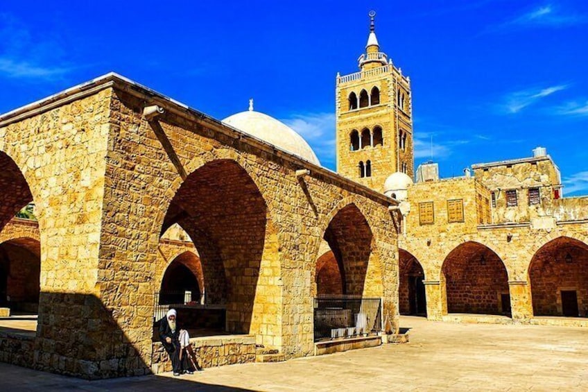 A historic stone building with arches and a tower. 3