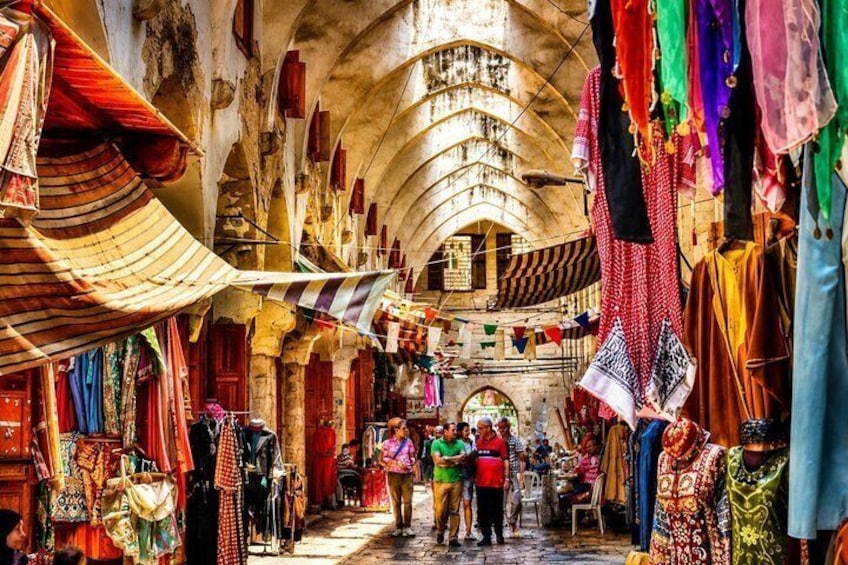 An indoor market with colorful textiles and traditional clothing. 2