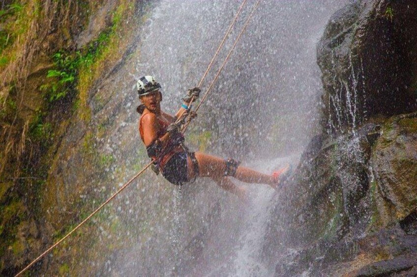 A person rappelling down a waterfall. 2
