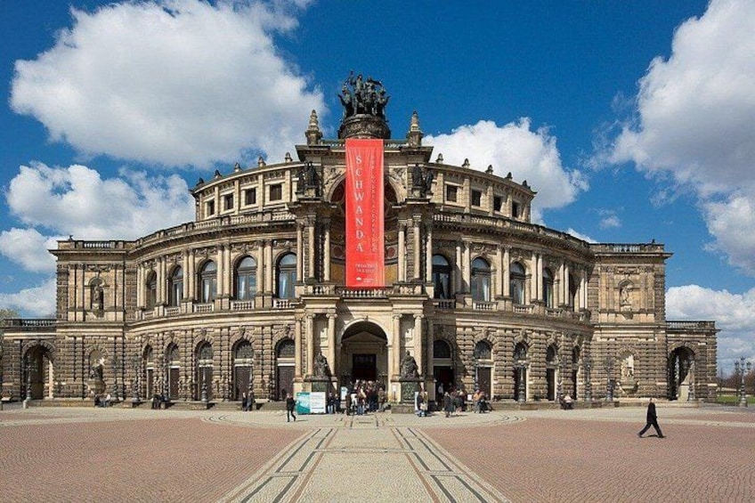 A historic building with a prominent central column and a large banner. 1