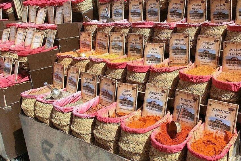 Variedad de especias expuestas en cestas tejidas con etiquetas. 2