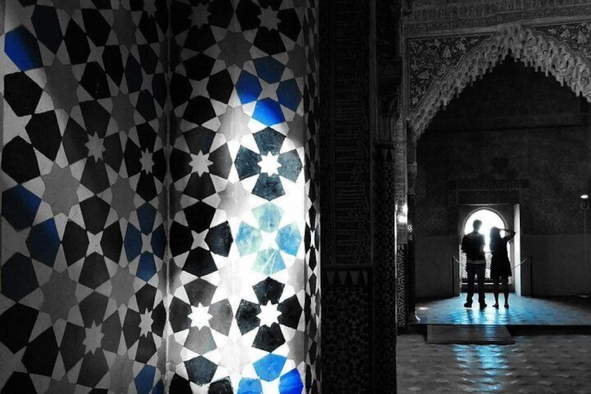A patterned wall with star designs and an arched doorway. 1