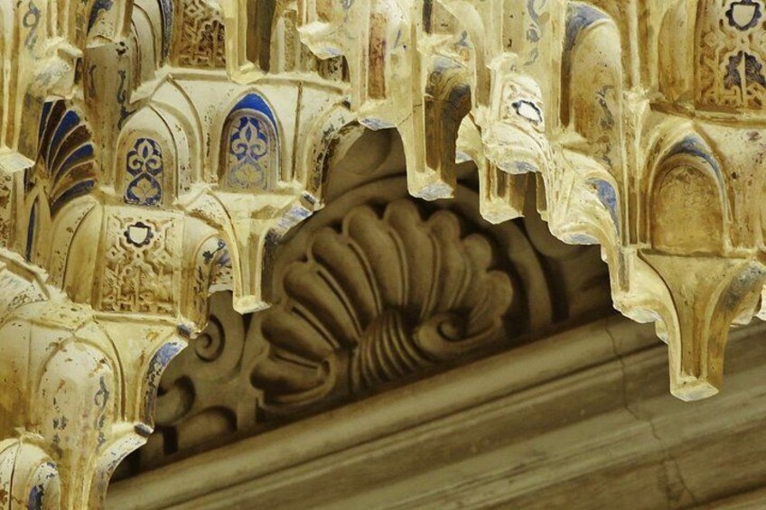 A detailed architectural carving with floral patterns and arched designs. 5