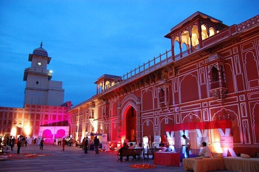 A historic building with ornate architecture and a clock tower, illuminated at dusk. 4