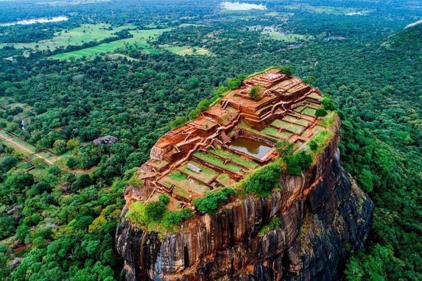An ancient stone structure perched on a cliff edge, surrounded by dense forest. 2