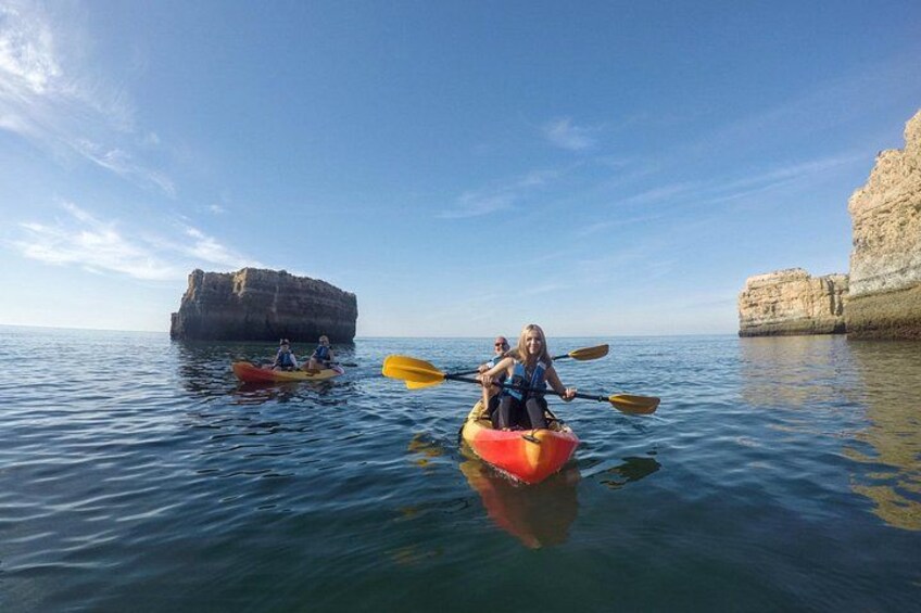 Three kayaks on calm water with cliffs in the background. 5