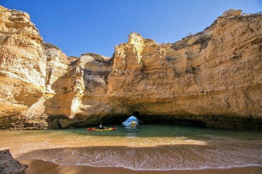 A cove with a boat and a person in a kayak. 2