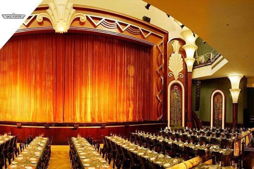 Une salle de spectacle où des rangées de tables sont disposées pour un événement. 2
