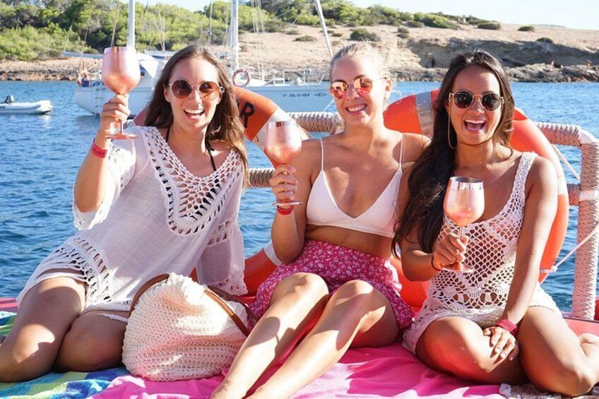 Three people on a boat with drinks, surrounded by water and boats. 3