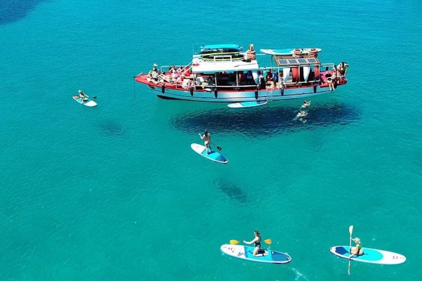 A large boat with people on it and several smaller boats with people paddling. 1