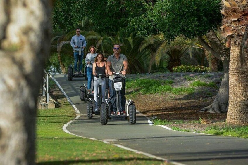 A paved path with people riding electric scooters. 5