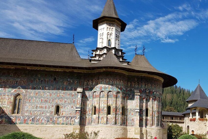 A historic building with a round tower and intricate wall paintings. 3