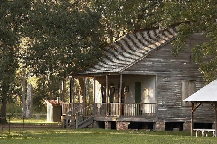 A rustic wooden building with a porch, surrounded by trees. 2
