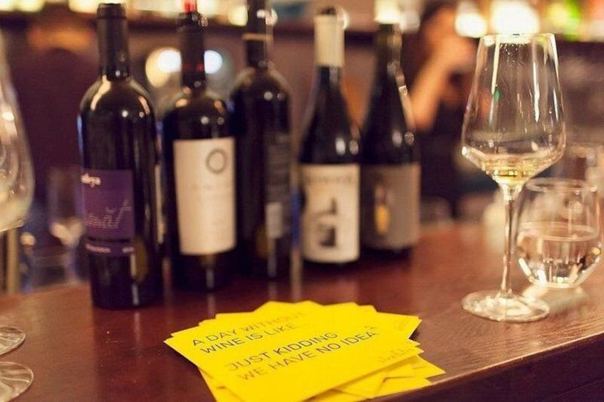 Un comptoir de bar avec des bouteilles de vin et des verres, ainsi que des post-it avec des messages écrits. 2