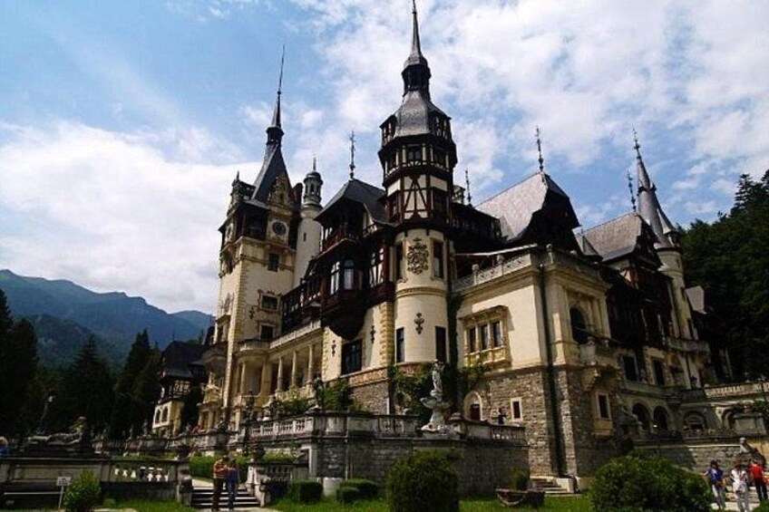 A historic castle with multiple towers and a well-maintained garden. 1